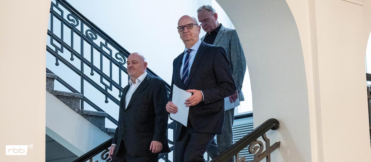 Brandenburgs Ministerpräsident Dietmar Woidke (SPD, mitte) und Robert Crumbach (l) kommen zu einem Pressestatement. (Quelle: dpa, Christophe Gateau)