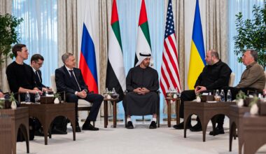 Mehrere Männer sitzen in einer Stuhlrunde zusammen und beraten.