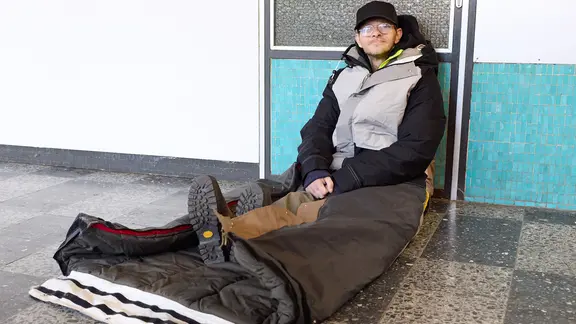 Ein Obdachloser mit einem Schlafsack