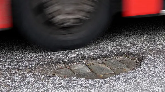 Ein Bus fährt an einem Schlagloch auf dem Mittelweg im Hamburger Stadtteil Rotherbaum vorbei.