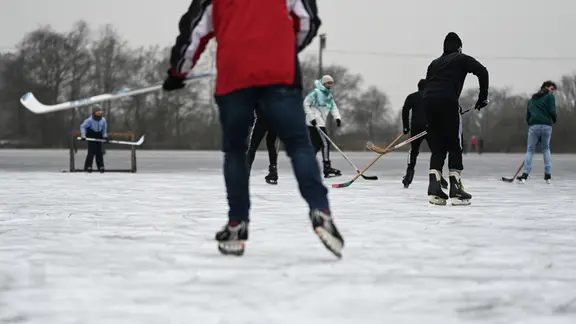 In Neermoor im Landkreis Leer ist auf dem Eis schon eine Menge los. | dpa, Lars Penning Eishockey-Spieler auf der zugefrorenen Fläche von Concordia Neermoor (Landkreis Leer)