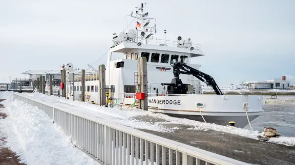 Ein Fährschiff für die Überfahrt zur Insel Wangerooge liegt bei frostigen Temperaturen im Hafen von Harlesiel.