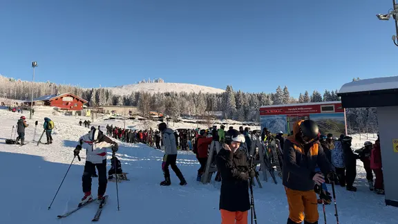 Wintersportler stehen im Schnee in einer Schlange vor der Wurmberg-Seilbahn.