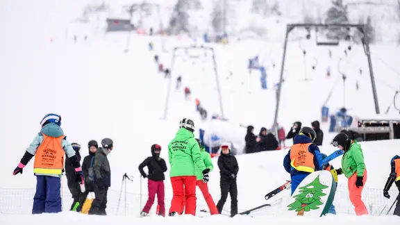 Skilehrer stehen mit Wintersportlern auf einer Skipiste am Wurmberg.