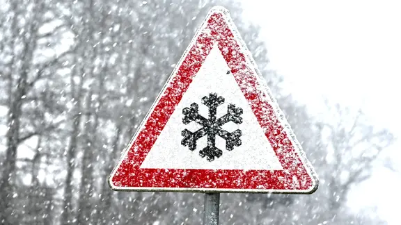 Schild warnt vor Schneeglätte.