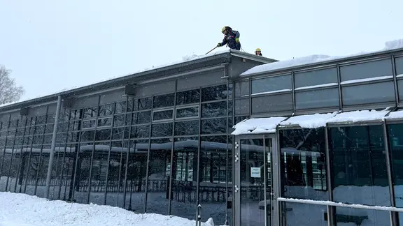 Das THW befreit das Hallendach der Theodor Heuß Schule in Pinneberg von Schnee.