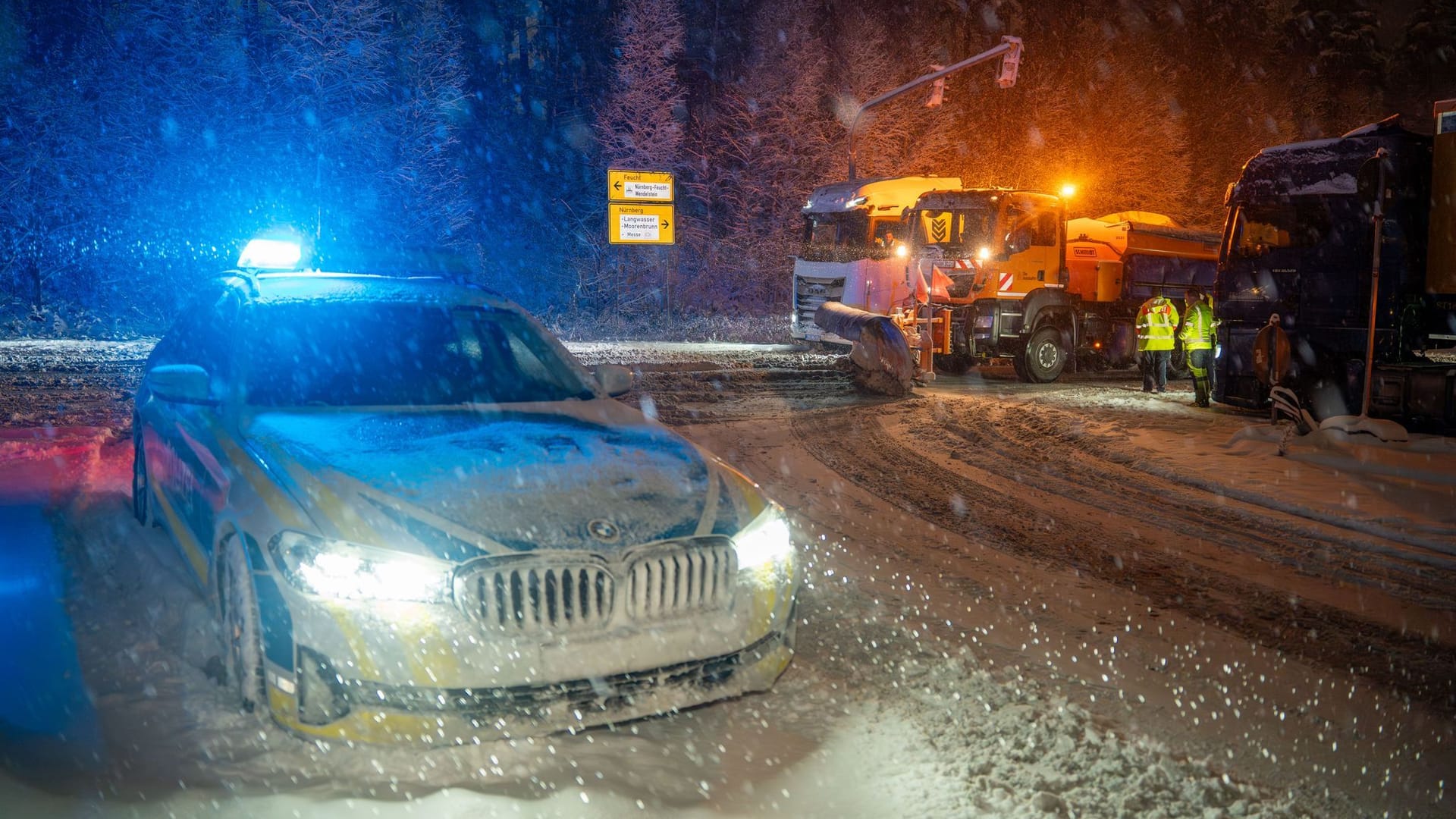 Schnee und Eisregen in Bayern: Während ein Streufahrzeug den Kreuzungsbereich an der Auffahrt zur A6 bei Nürnberg räumt, sperrt die Polizei die Zufahrt: