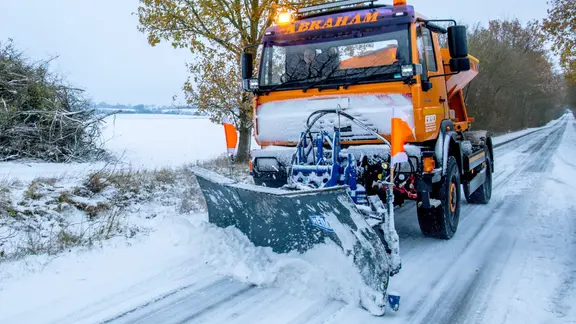 Ein Schneepflug räumt eine Straße bei Möllin in Mecklenburg-Vorpommern.