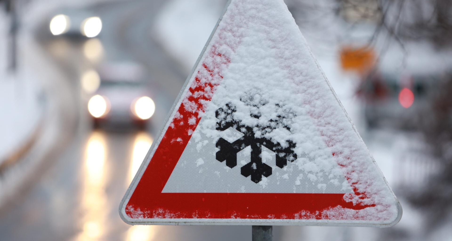 Ein Verkehrszeichen mit Schneeflocke warnt vor Glätte.