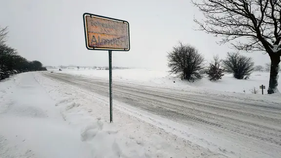 Ein verschneites Ortseingangsschild.