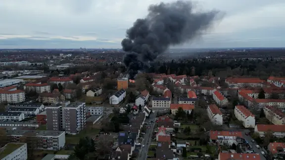 Eine riesige Rauchwolke ist über einem brennenden Schulgebäude zu sehen.