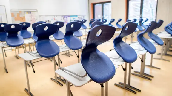 Stühle stehen auf Tischen in einem leeren Klassenraum in einem Gymnasium. | dpa, Hauke-Christian Dittrich Stühle stehen auf Tischen in einem leeren Klassenraum in einem Gymnasium.