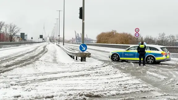 Ein Polizeiwagen steht vor der wegen Glätte gesperrten Köhlbrandbrücke. | Screenshot Ein Polizeiwagen steht vor der wegen Glätte gesperrten Köhlbrandbrücke.