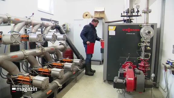 Ein Mann steht in einem Heizungsraum.