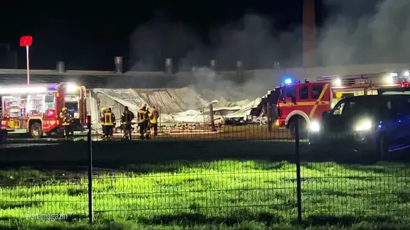 Einsatzkräfte der Feuerwehr löschen einen Brand. 