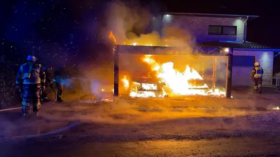 Feuerwehrleute löschen zwei brennende Autos in einem Carport in Buchholz. | TeleNewsNetwork Feuerwehrleute löschen zwei brennende Autos in einem Carport in Buchholz.