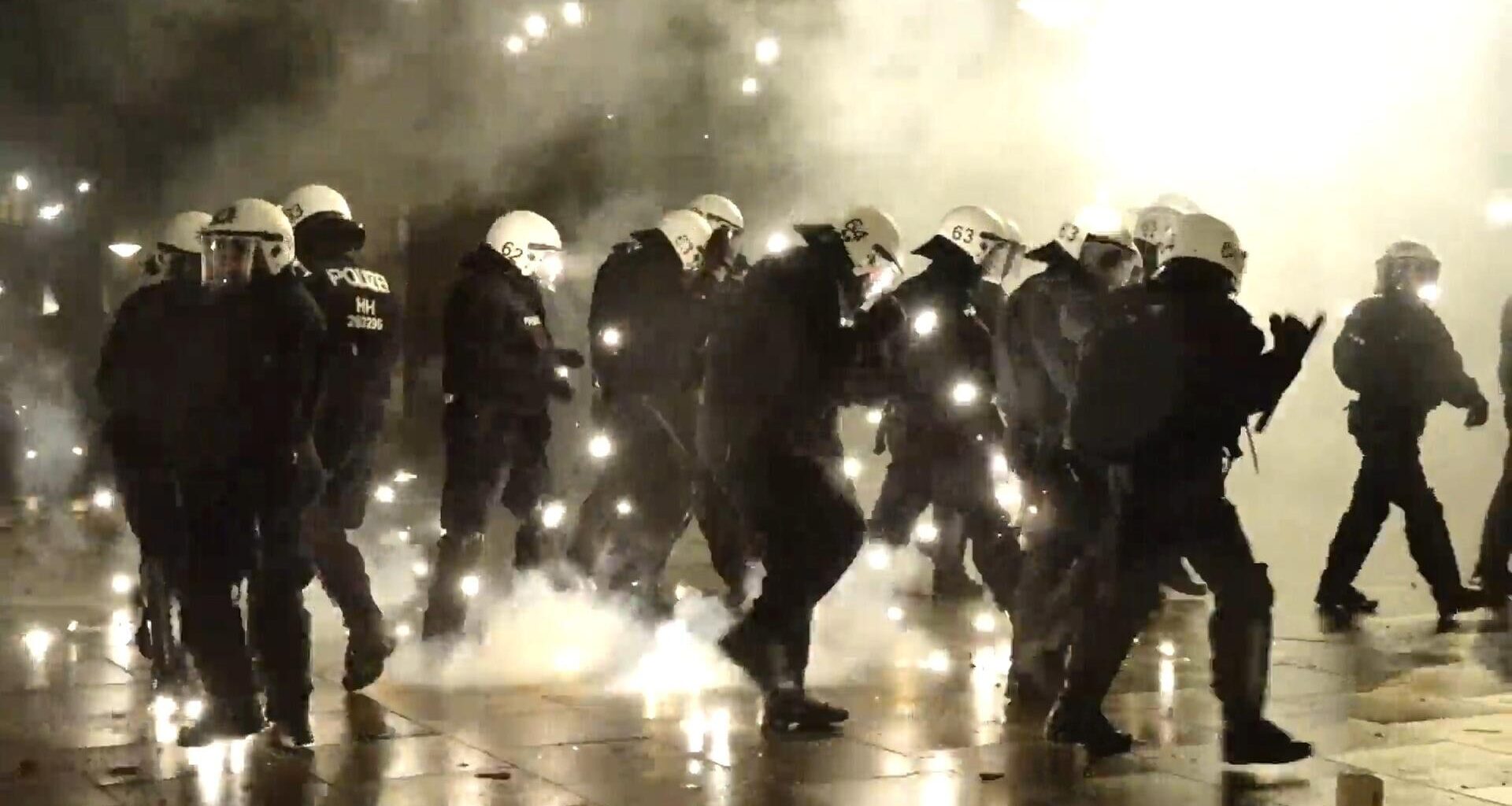Ein Standbild aus einem Video zeigt Einsatzkräfte der Polizei inmitten von Pyrotechnik in Hamburg.