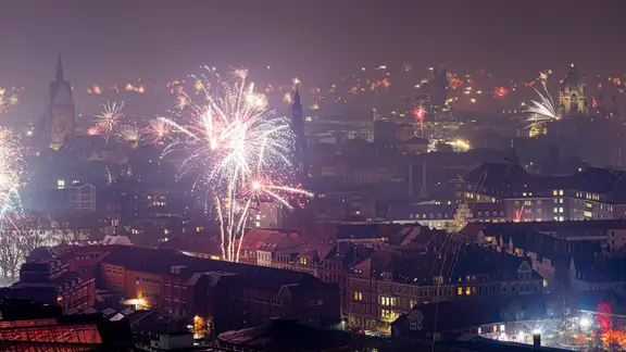 Feuerwerk explodiert in der Silvesternacht am Himmel neben der Marktkirche und dem Neuen Rathaus in Hannover. | Moritz Frankenberg/dpa +++ dpa-Bildfunk +++ Feuerwerk explodiert in der Silvesternacht am Himmel neben der Marktkirche und dem Neuen Rathaus in Hannover.