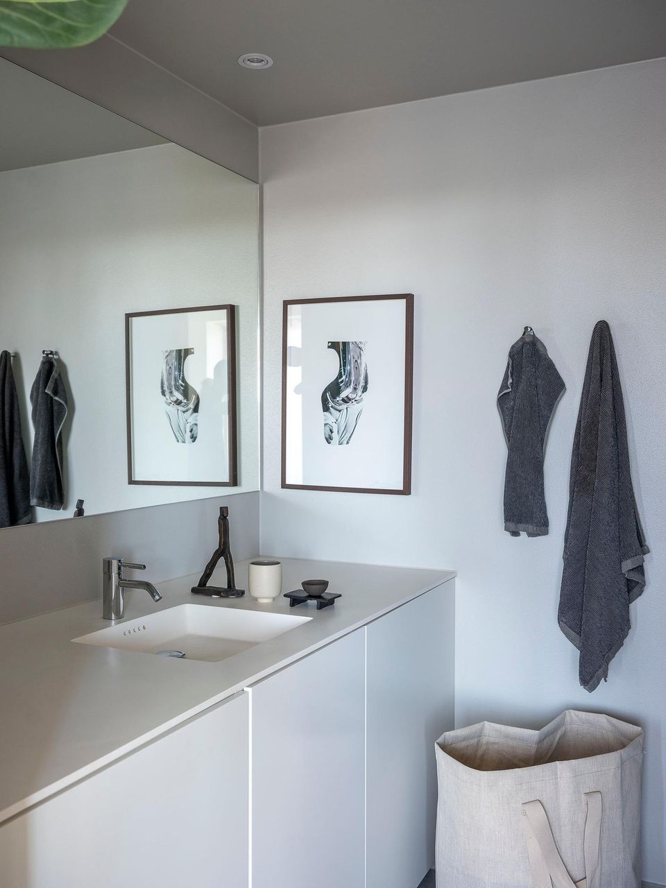 Ausschnitt aus dem Badezimmer mit Handtüchern, großem Spiegel und großem Waschbecken-Unterschrank