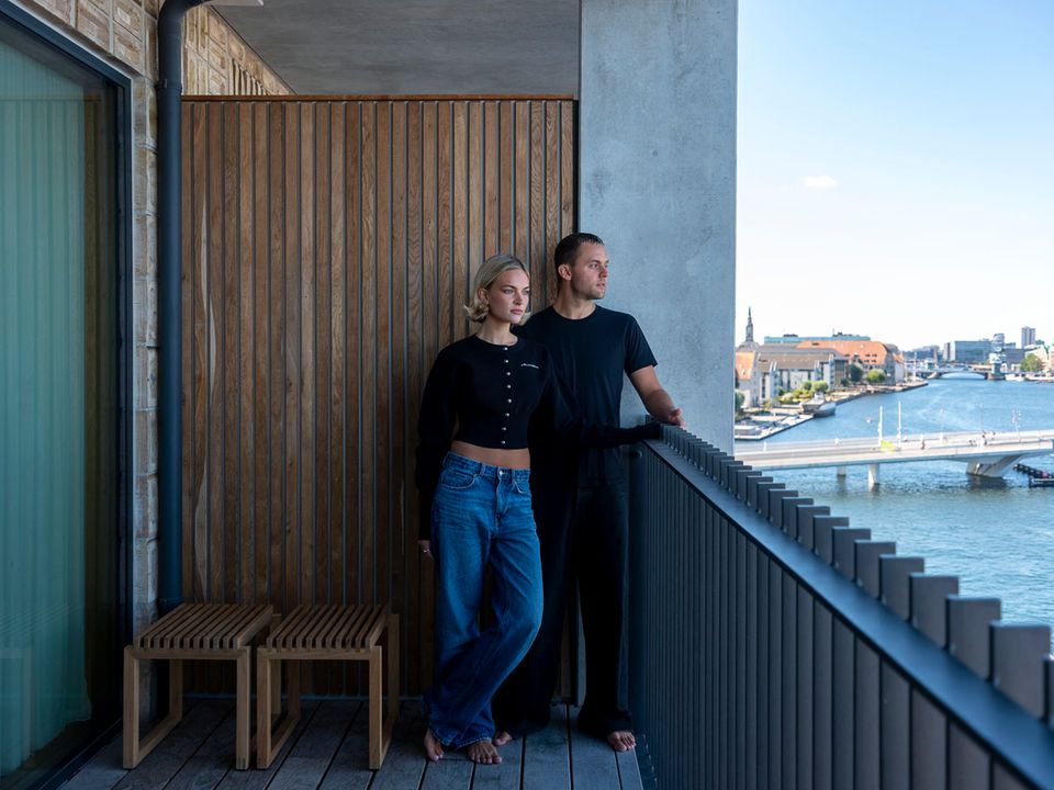 Das Paar auf dem Balkon mit Blick aufs Wasser