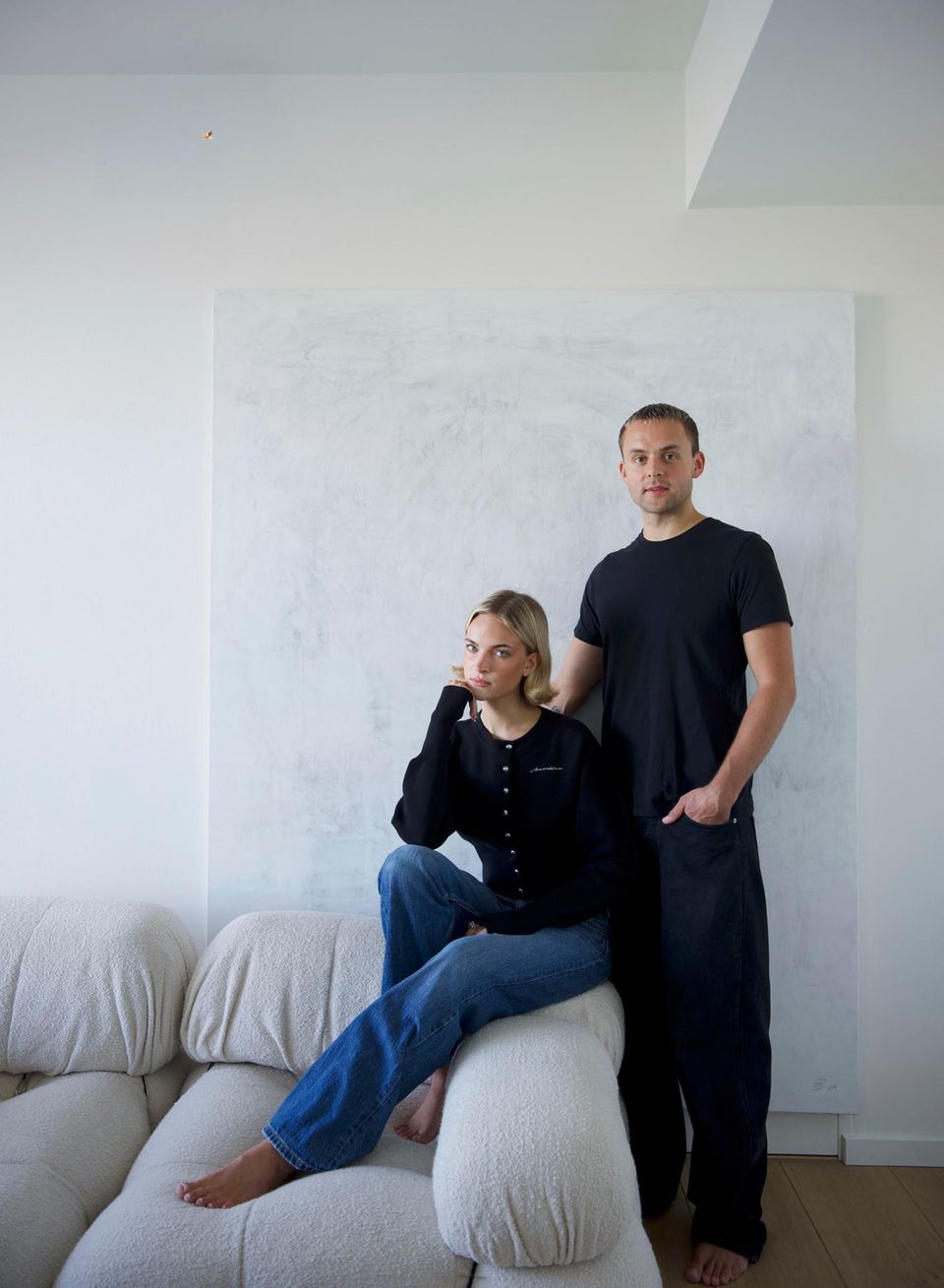 Paar auf der Couch vor einem großen weißen Gemälde