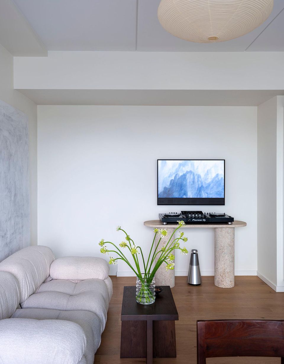 Wohnbereich mit Couch und Stein-Sideboard mit Fernseher