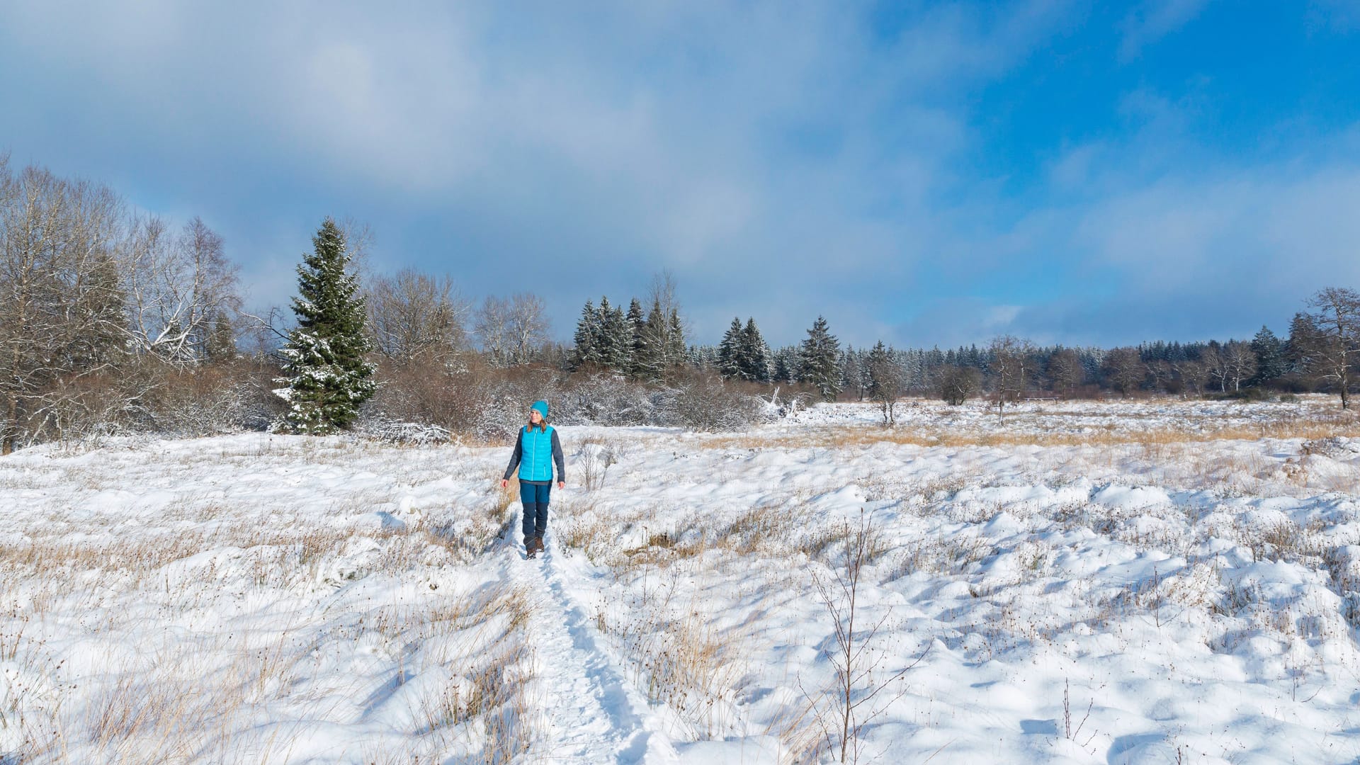 Spaziergängerin im Schnee (Symbolfoto): In der Städteregion wird es zum Wochenende wohl weiß.