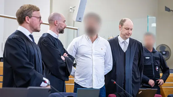 Der Angeklagte, ein Staatsanwalt aus Hannover, kommt zum Auftakt eines Prozesses wegen Bestechlichkeit und Verletzung des Dienstgeheimnisses in einen Saal des Landgerichts Hannover. | dpa, Moritz Frankenberg Der Angeklagte, ein Staatsanwalt aus Hannover, kommt zum Auftakt eines Prozesses wegen Bestechlichkeit und Verletzung des Dienstgeheimnisses in einen Saal des Landgerichts Hannover.