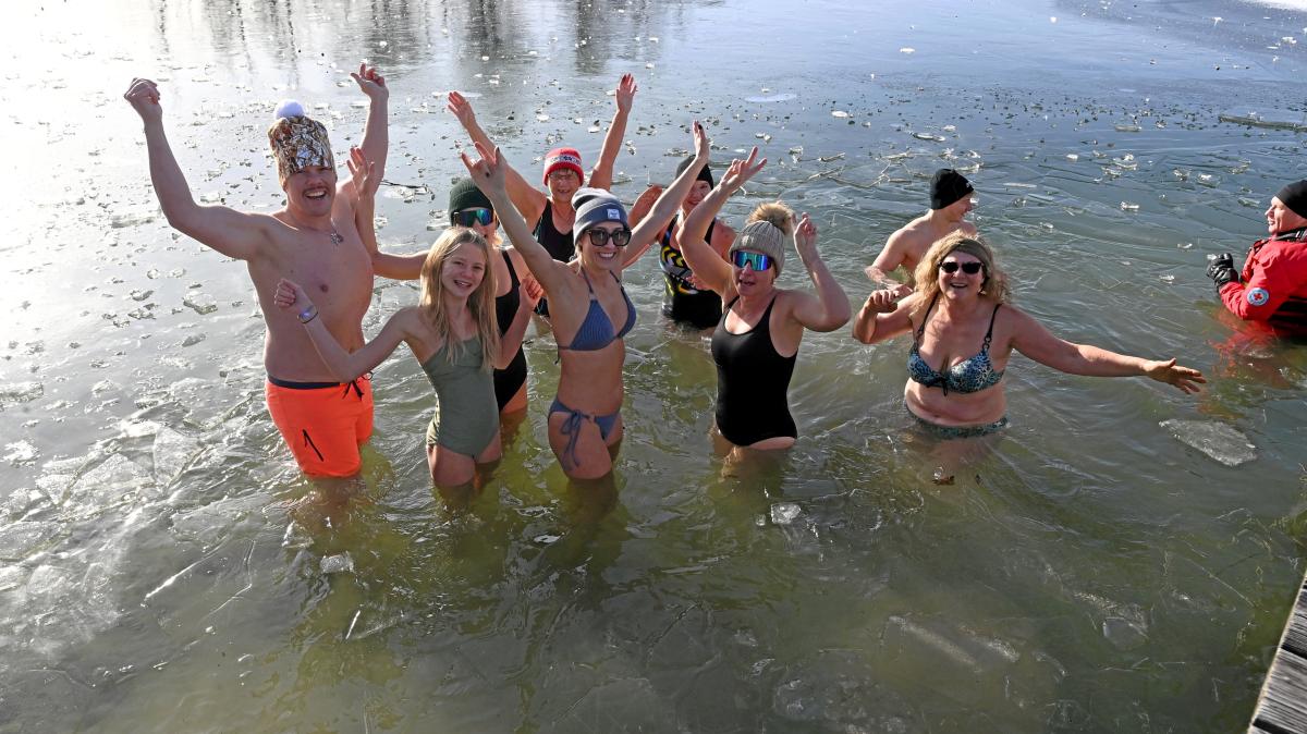 Schwimmer springen in den Autobahnsee