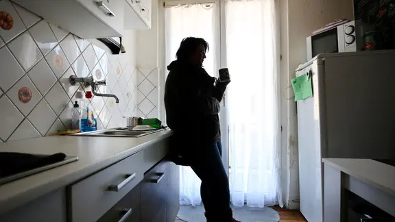 Eine Frau steht in einer Küche, nachdem der Strom abgedreht wurde. | picture alliance / Roland Weihrauch/dpa | Roland Weihrauch Eine Frau steht in einer Küche, nachdem der Strom abgedreht wurde.