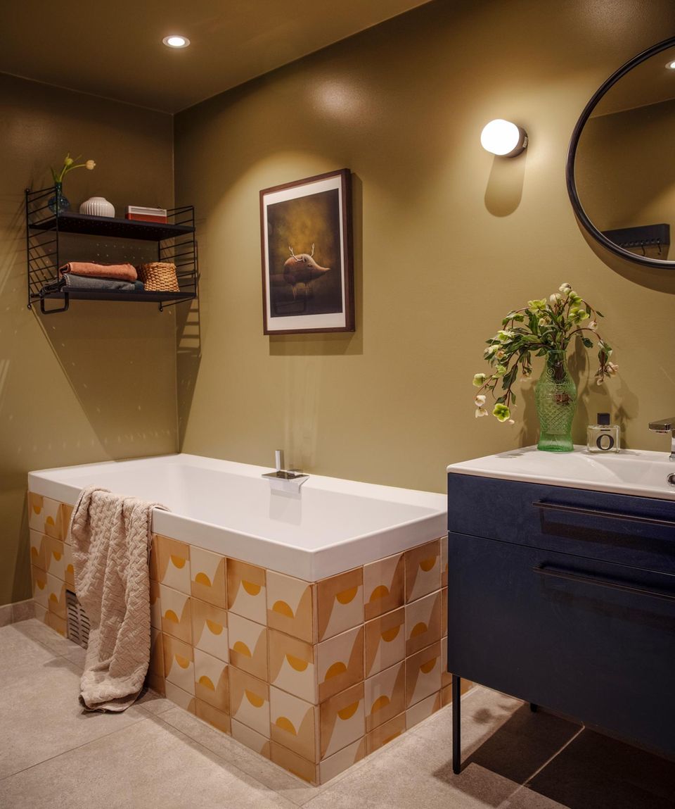 Gelbes Badezimmer mit Badewanne, Wandregal und Waschtisch