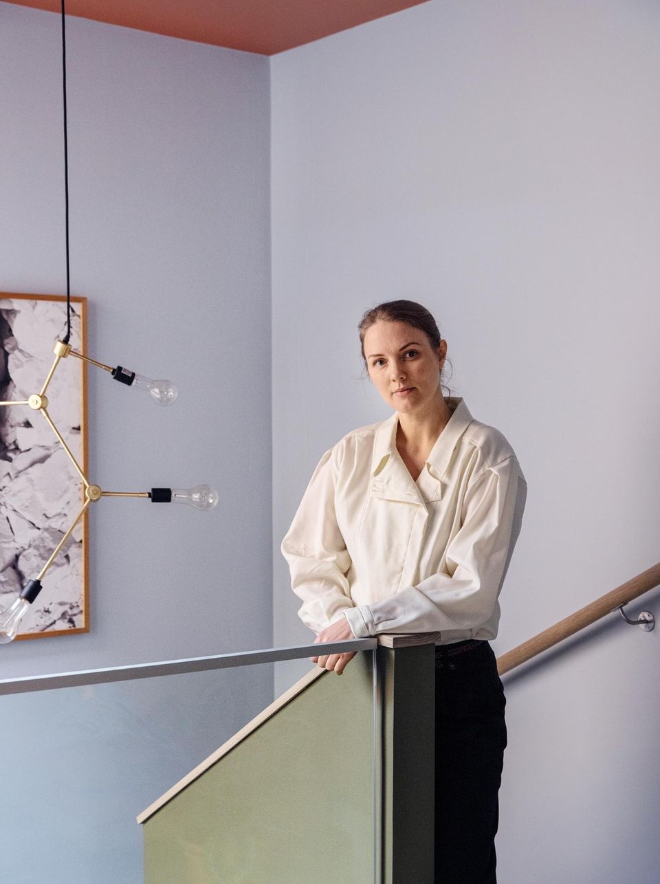 Frau in einem hellblauen Treppenhaus