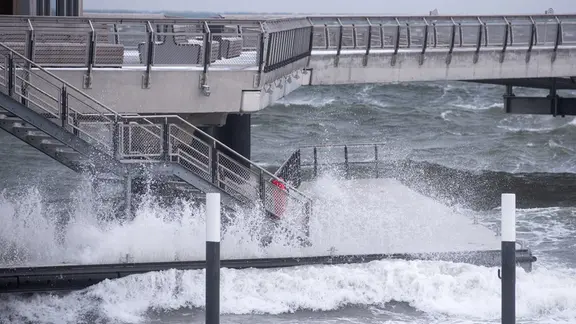 Wellen schlagen gegen die Seebrücke in Haffkrug.