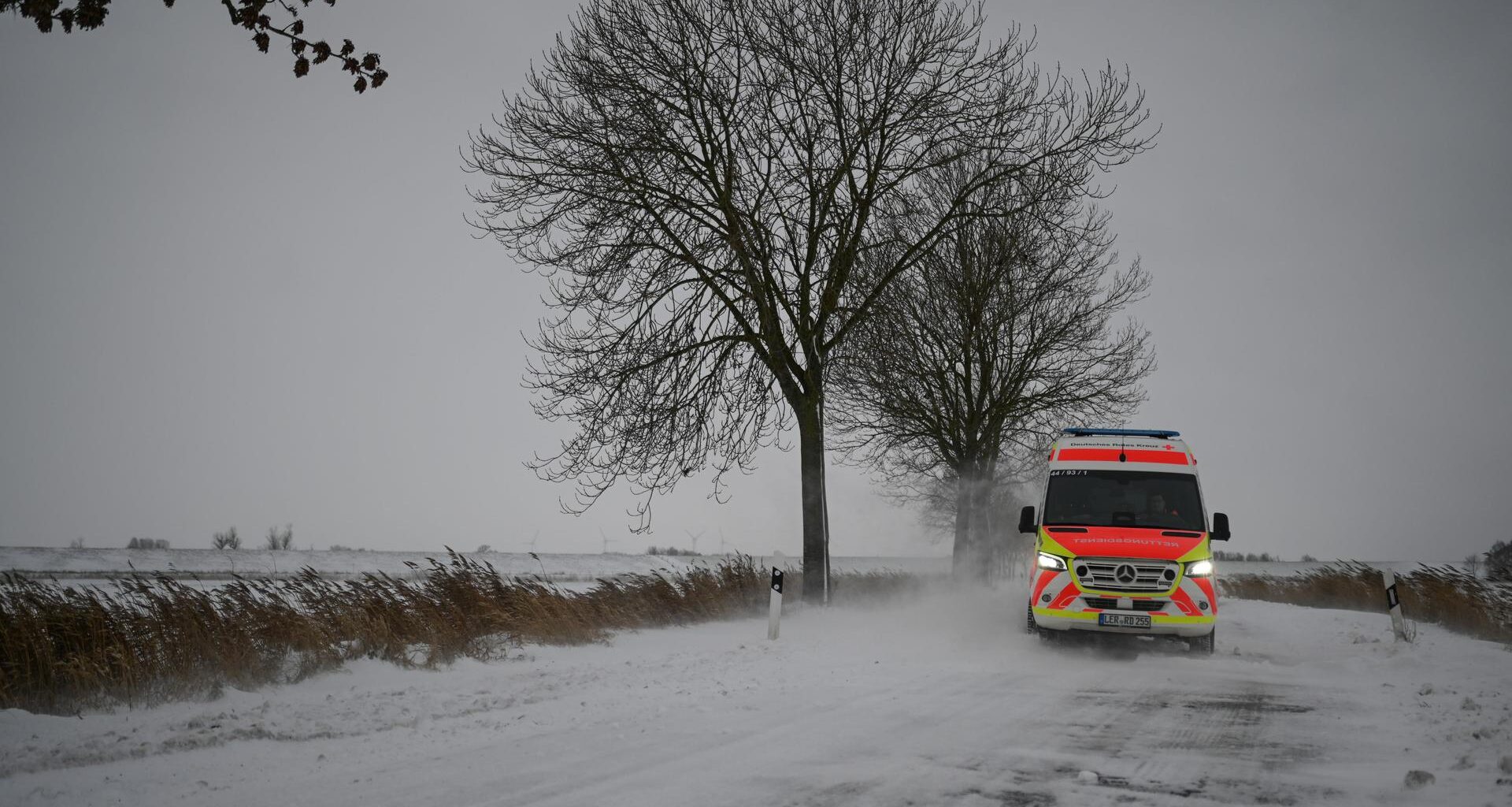 Ein Rettungswagen weicht Schneeverwehungen aus.