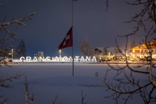 Attendees gather in mourning, placing messages, candles, and flowers at a memorial site in front of the bar “Le Constellation” during a national day of mourning in Crans-Montana, on January 9, 2026, in tribute to the victims of the fire that ravaged the bar on New Year’s Eve, killing 40 people and injuring 116 others, most of them teenagers. All of Switzerland will mark a national day of mourning on January 9 for the dozens of mostly teenagers killed when fire ravaged a ski resort bar crammed with New Year revellers. Just over a week after the tragedy at the Le Constellation bar in Crans-Montana, which left 40 dead and 116 injured, the wealthy Alpine nation will come to a standstill for a minute of silence at 2:00 pm (1300 GMT). (Photo by MAXIME SCHMID / AFP)