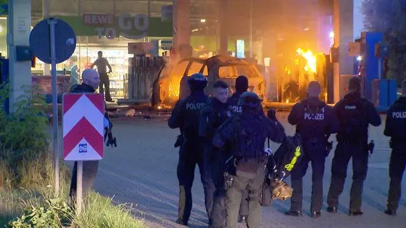 Einsatzkräfte des SEK stehen vor einem brennenden Auto auf einer Tankstelle in Hannover Anderten. | NonstopNews Einsatzkräfte des SEK stehen vor einem brennenden Auto auf einer Tankstelle in Hannover Anderten.