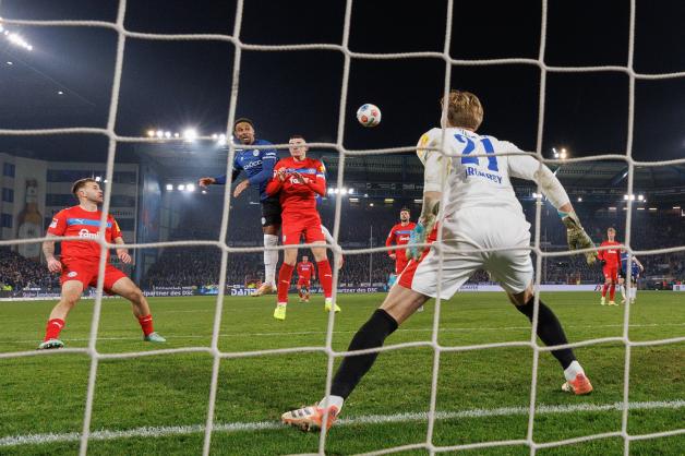 Der Ausgleich für Arminia Bielefeld gegen Holstein Kiel: Noah Sarenren Bazee (blaues Trikot) steigt hoch und gibt mit seinem Kopfball den Gästeakteuren Marco Komenda (von links), David Zec und Jonas Krumrey das Nachsehen.