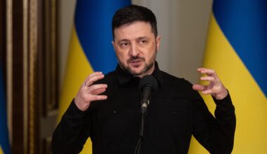 Wolodymyr Selenskyj, Präsident der Ukraine, spricht während eines Briefings. Hinter ihm sind ukrainische Flaggen zu sehen.