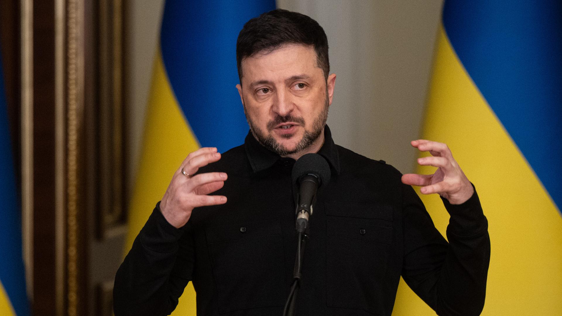 Wolodymyr Selenskyj, Präsident der Ukraine, spricht während eines Briefings. Hinter ihm sind ukrainische Flaggen zu sehen. Wolodymyr Selenskyj, Präsident der Ukraine, spricht während eines Briefings. Hinter ihm sind ukrainische Flaggen zu sehen.