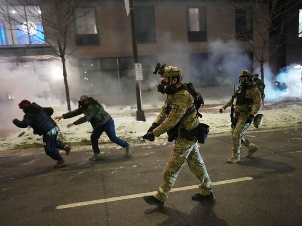 25.01.2026, USA, Minneapolis: US-Bundesagenten versuchen Demonstranten in der Nähe eines Hotels zu vertreiben, indem sie Tränengas während einer Lärmdemonstration als Reaktion auf Bundeseinwanderungsmaßnahmen in der Stadt in Minneapolis einsetzen. Foto: Adam Gray/AP/dpa +++ dpa-Bildfunk +++
