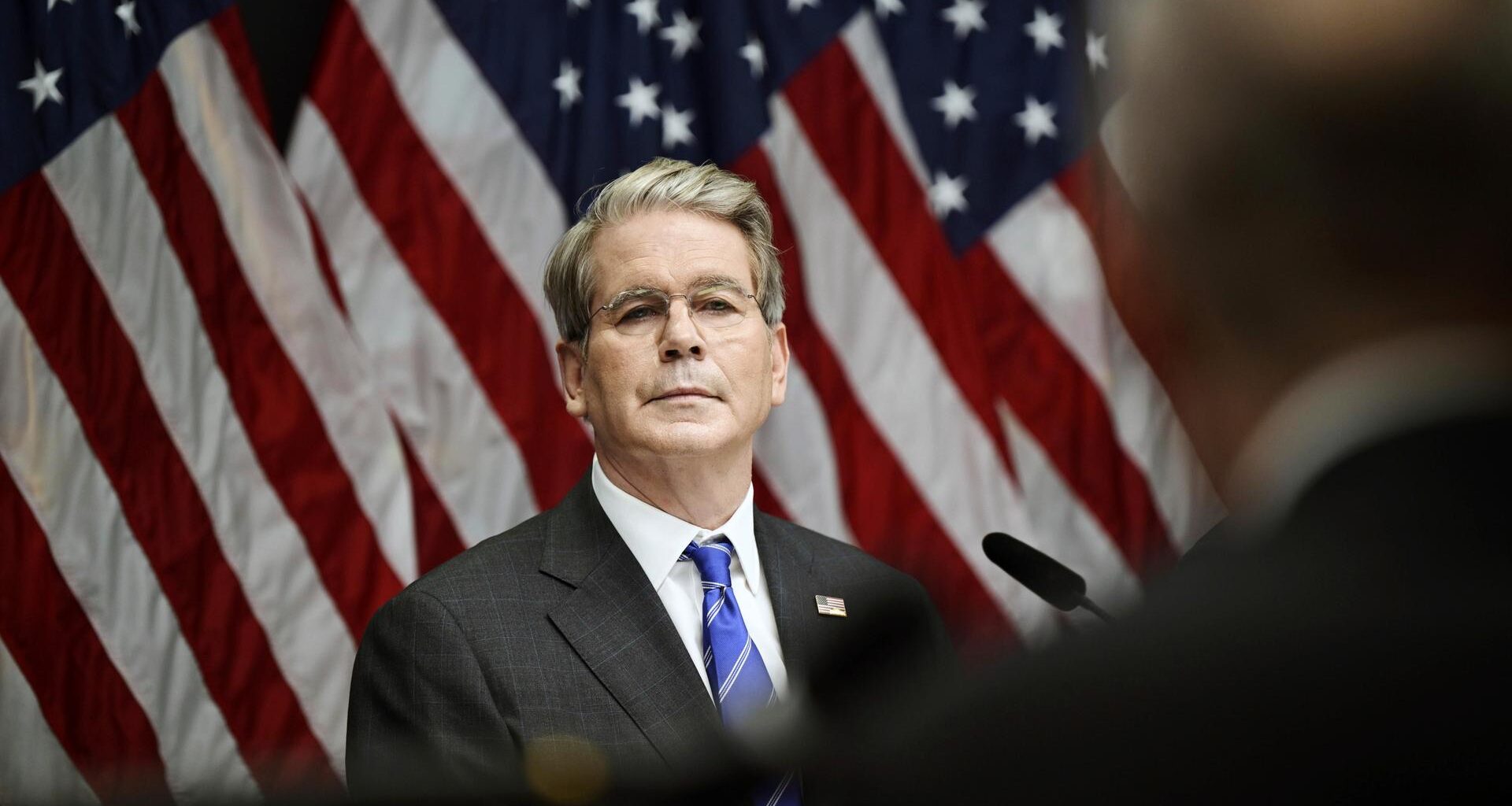 US-Finanzminister Bessent steht vor mehreren US-Flaggen.