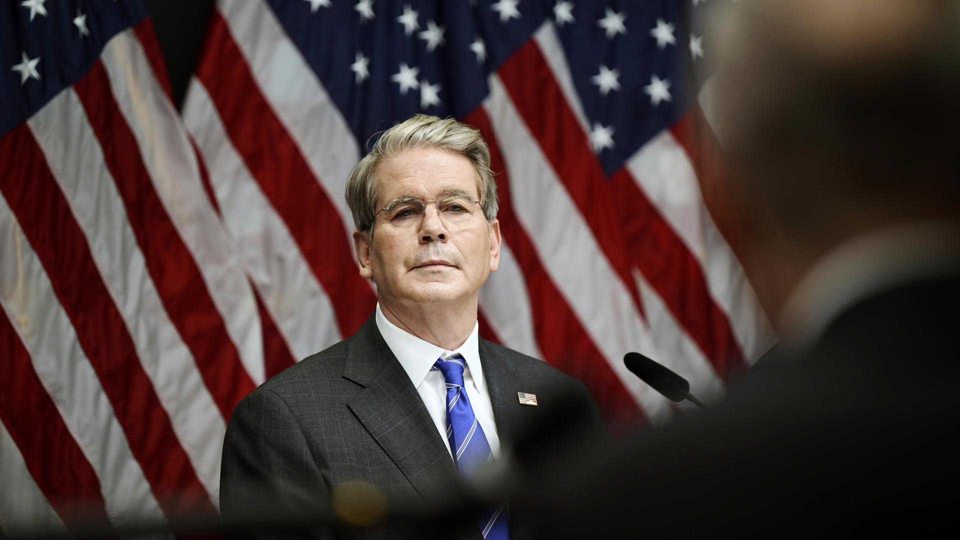 US-Finanzminister Bessent steht vor mehreren US-Flaggen.