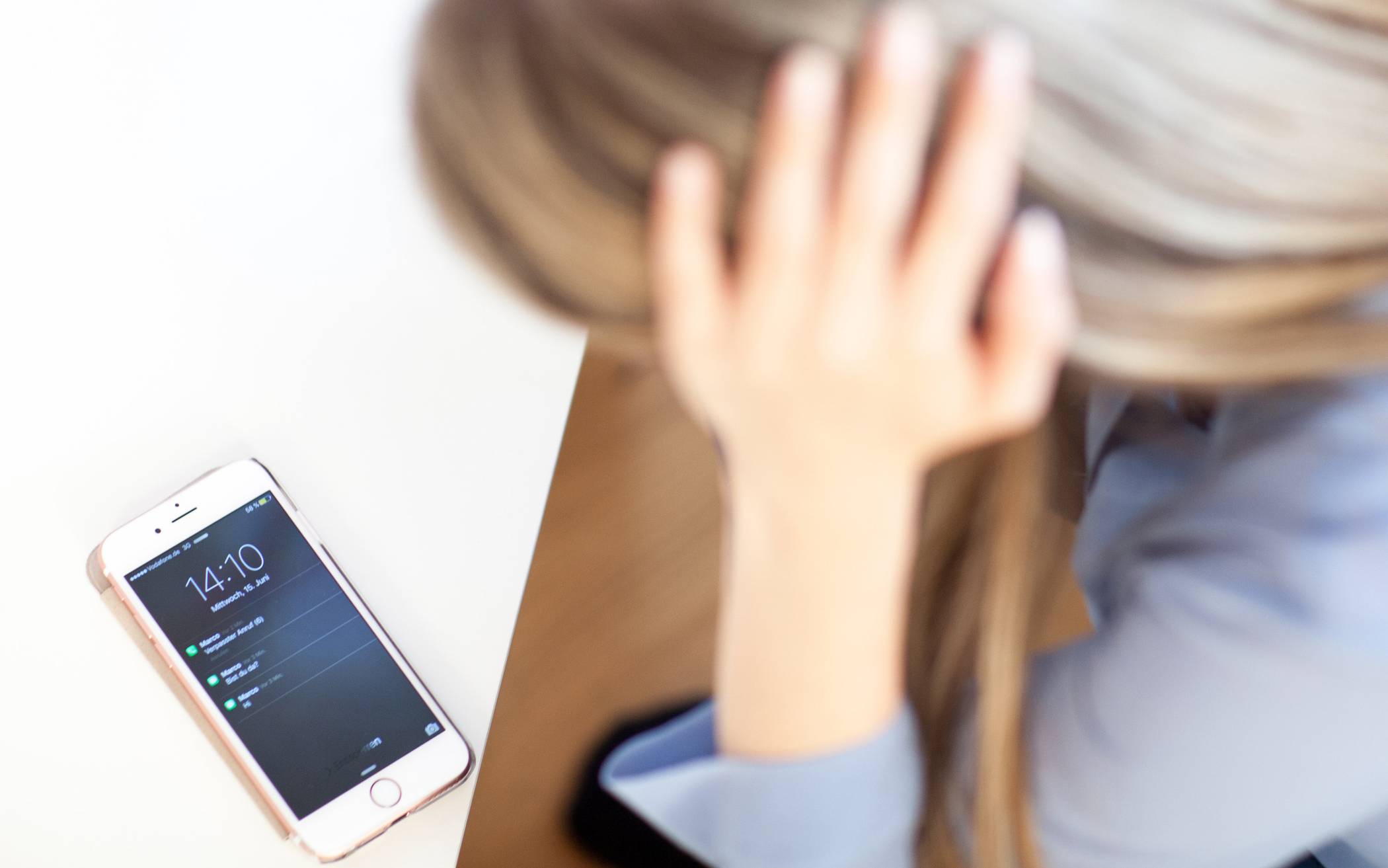 Ein Frau lehnt über einem Smartphone.