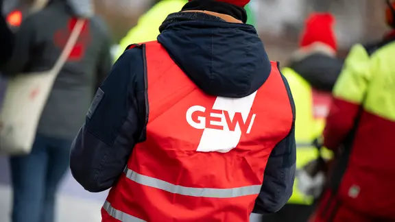 Ein Teilnehmer einer Demonstration in Schwerin trägt eine Warnweste mit dem Logo der Gewerkschaft Erziehung und Wissenschaft (GEW).