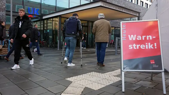 Weil an UKSH-Standorten in Kiel und Lübeck Warnstreiks stattfinden, werden auf dem gesamten Gebiet Schilder aufgestellt. | NDR, Tyadina Lahmann Ein Schild mit der Aufschrift "Heute: Warnstreik!" steht vor dem Eingang des Universitätsklinikum Schleswig-Holstein.