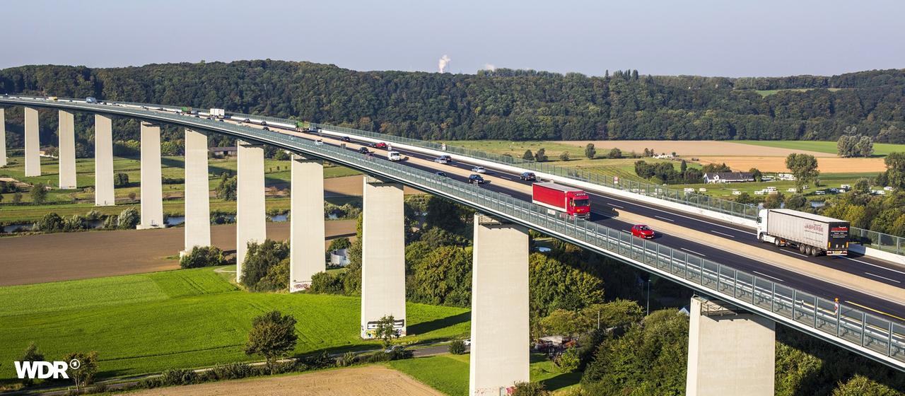 Ruhrtalbrücke in NRW | newspixx vario images Eine lange Autobahnbrücke erstreckt sich über eine grüne Landschaft.