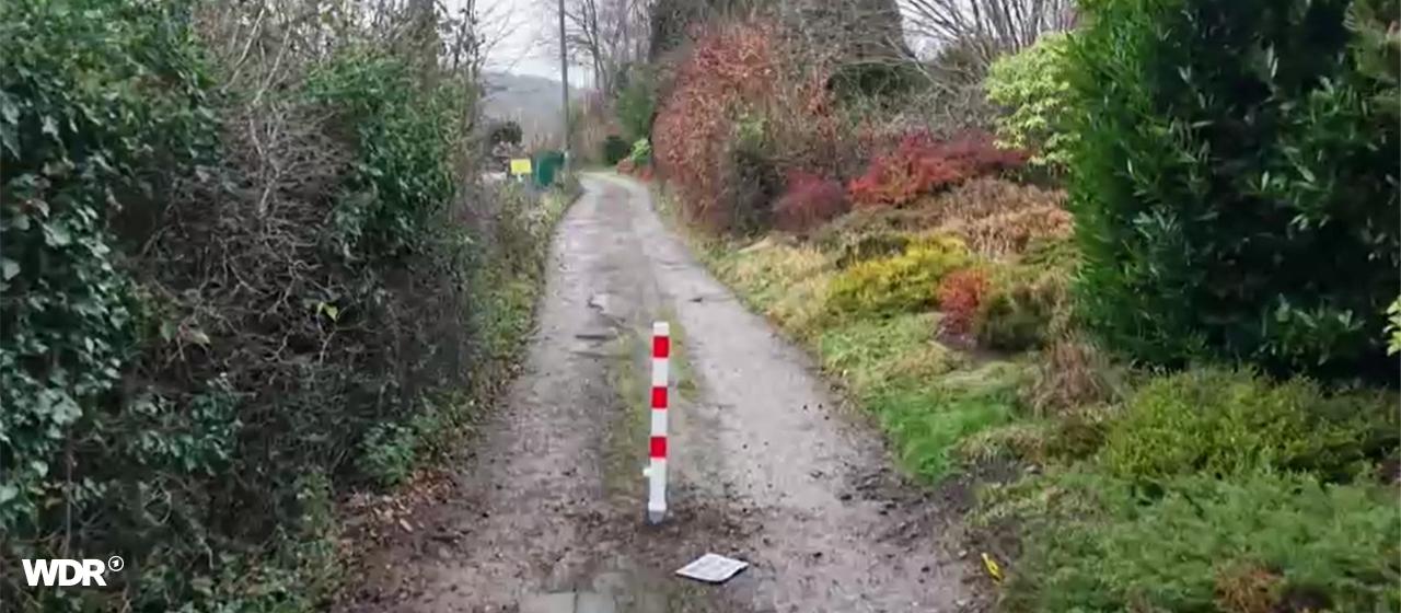 Ein Weg, in der Mitte steht ein Poller. 