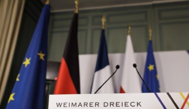 Ein Rednerpult steht vor der Pressekonferenz im Rahmen des Treffen des Weimarer Dreiecks im Schloss de la Celle in La Celle-Saint-Cloud am 12.02.2024 in einem Saal. Dahinter die Länder- und die EU-Fahnen.