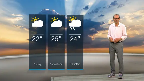 NDR Moderator Meeno Schrader steht im Studio mit der Wettervorhersage.