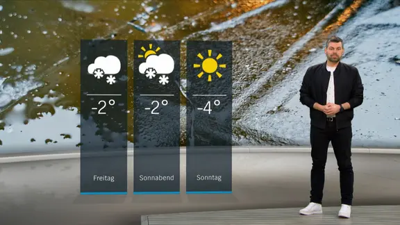 Wetterexperte Sebastian Wache steht im Studio mit der Wettervorhersage.